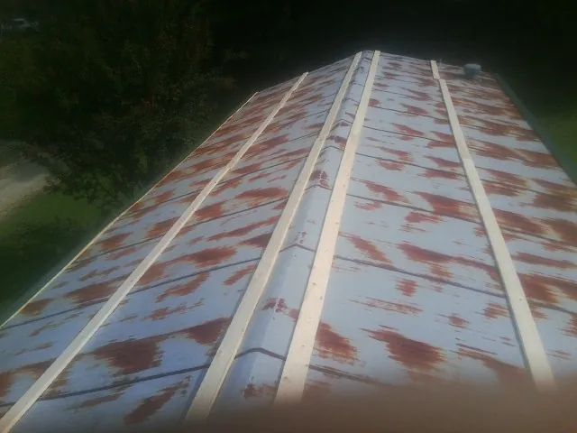Rusted metal roof panels with new wood purlins before replacement — Storm Damage Roof Repair in Casnovia by Roofing Brothers