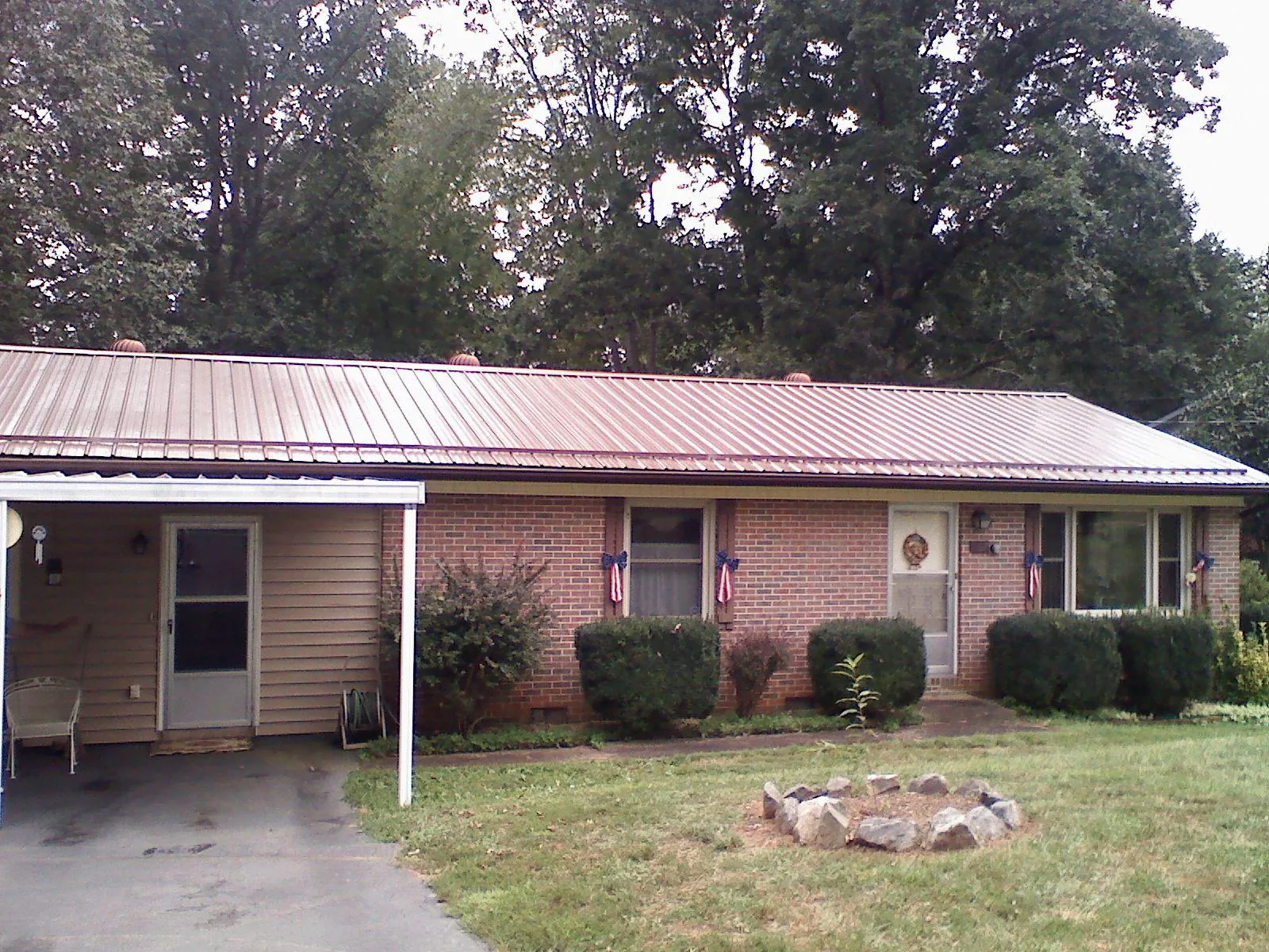 Bronze metal roof and carport on a brick ranch home — Roof Repair work by our crew in Casnovia